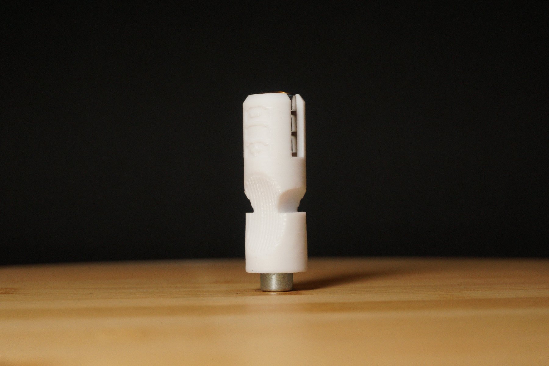 Weißer PX21-Batterieadapter, aufrecht stehend vor dunklem Hintergrund.