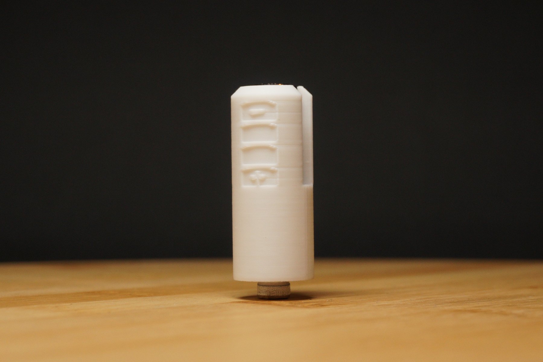 Weißer PX32-Batterieadapter, aufrecht stehend vor dunklem Hintergrund.